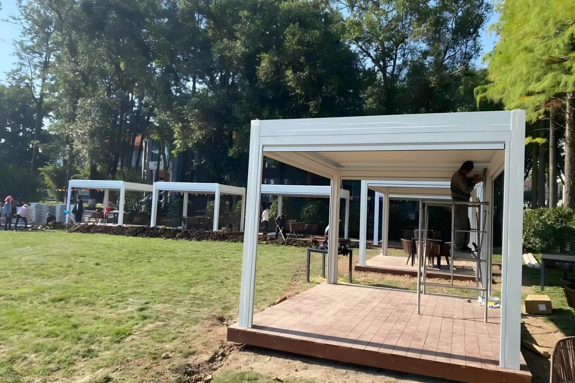 Close-up of a detailed structural engineering blueprint for a custom aluminum pergola, with a gloved hand using a measurement tool, representing our technical precision and design compliance.