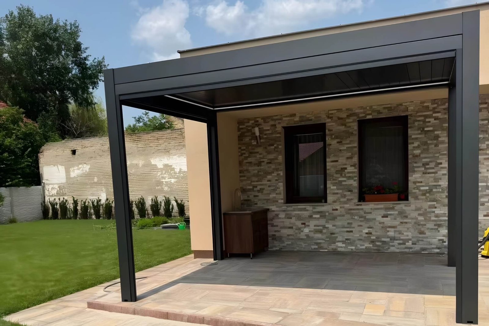 Custom dark grey aluminum pergola attached to a home in Cancun, featuring a specialized anti-corrosion coating to withstand salty coastal winds.