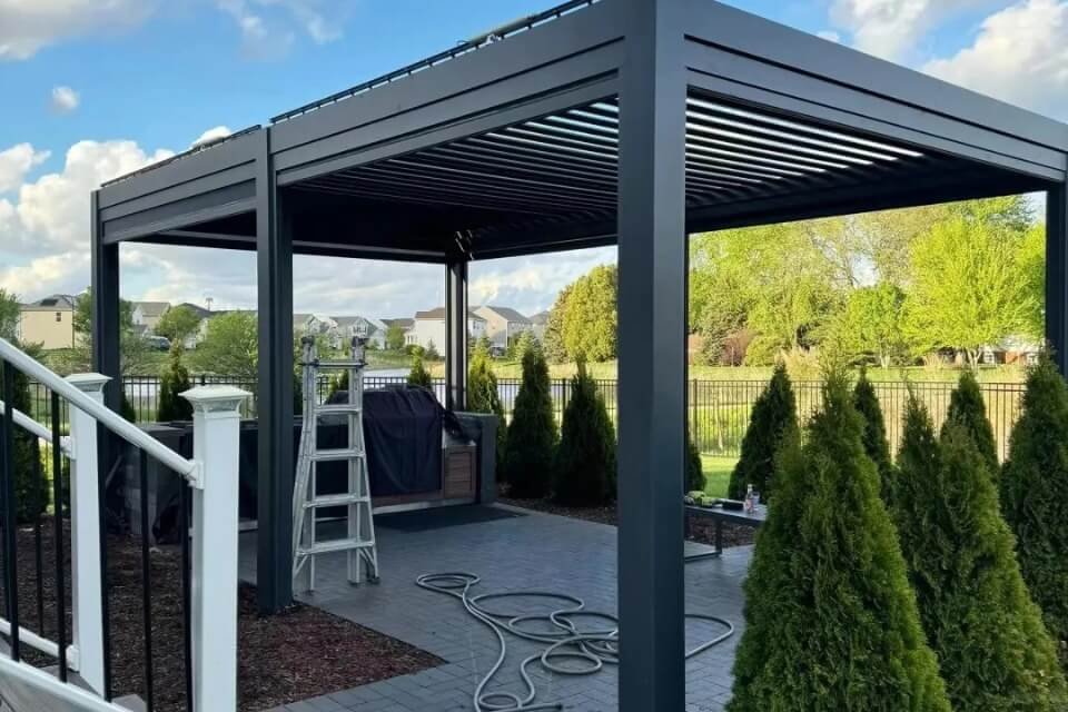 Luxury outdoor living space featuring a custom motorized pergola with adjustable louvers on an NZ coastal deck, maximizing comfort and panoramic views.