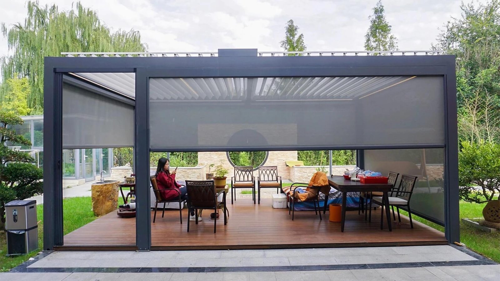 Premium bioclimatic aluminum pergola with open louvers and lowered zip screens, demonstrating our custom factory-direct outdoor structures for commercial and residential projects.