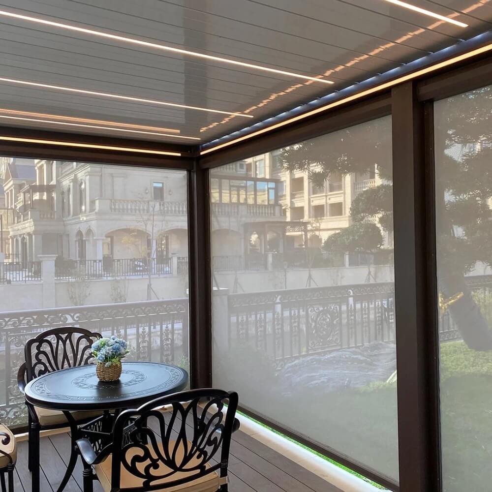 Aluminum bioclimatic pergola fully enclosed with heavy-duty frameless glass sliding doors, creating a weather-protected 4-season outdoor sunroom.