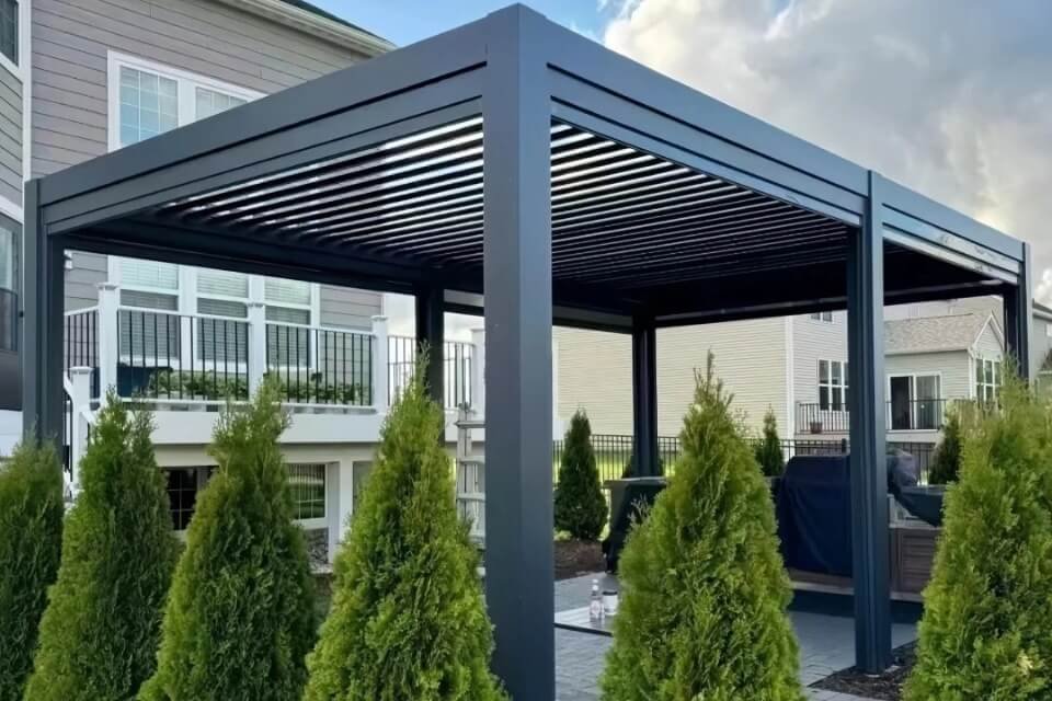 Flawlessly installed Oude motorized aluminum pergola at a private luxury residence in New Zealand with a stunning coastal view, engineered for extreme wind loads.