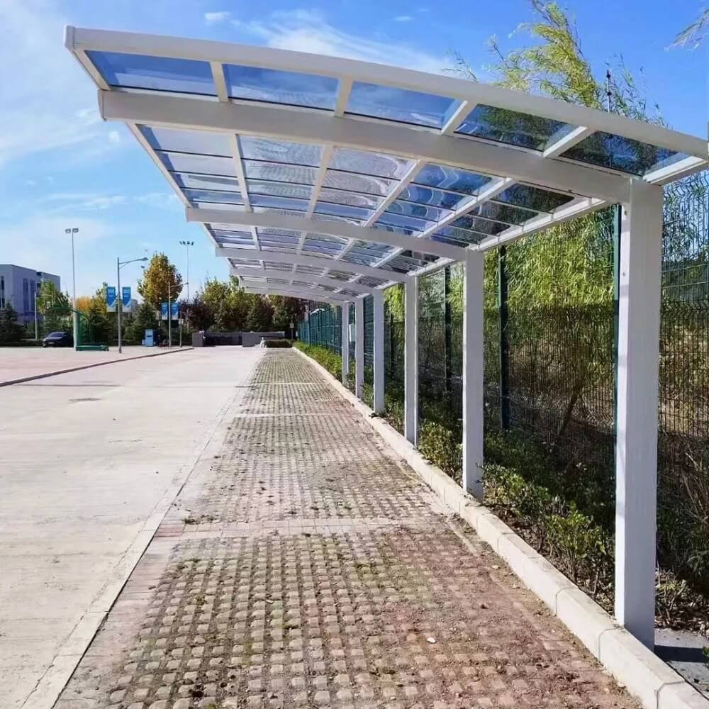 A long, continuous white aluminum cantilever carport demonstrating the modular expansion system, with multiple units linked together to provide extensive coverage for commercial parking.