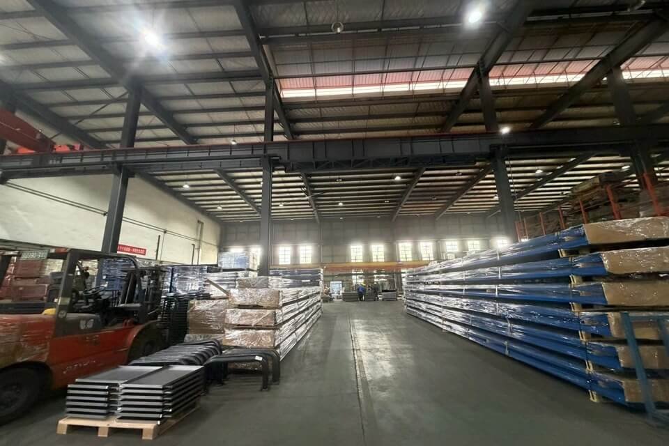 Extensive warehouse at Oude Outdoor's 15,000m² facility, showcasing massive inventory of raw aluminum profiles and logistics equipment for global OEM production.