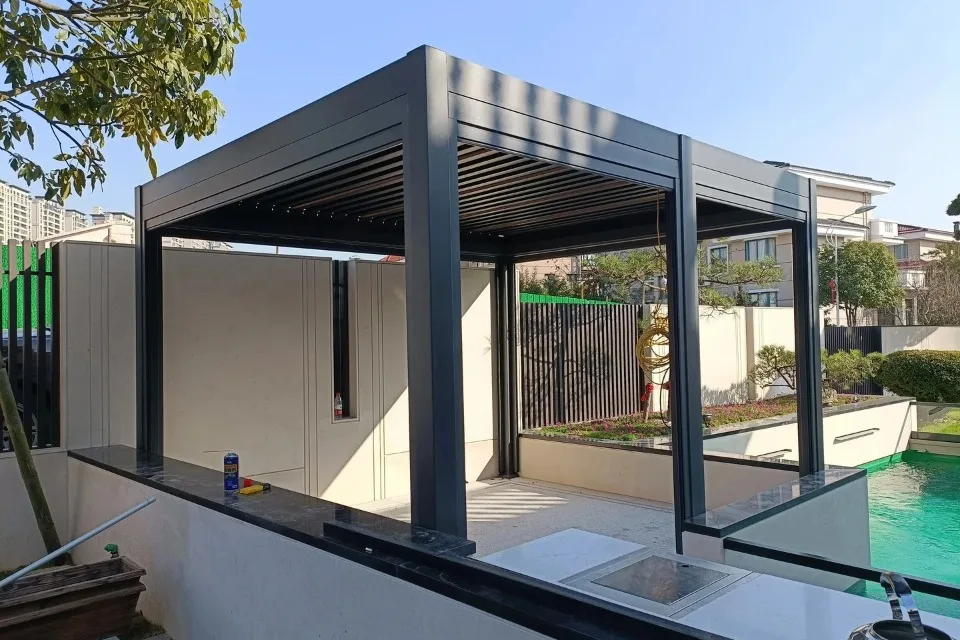 Daytime view of a moisture-resistant, rust-proof bioclimatic pergola installed directly on the edge of a luxury villa swimming pool.