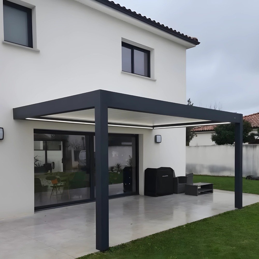 Modern dark grey wall-mounted aluminum pergola securely attached to a residential home, extending the indoor living space to an outdoor patio.