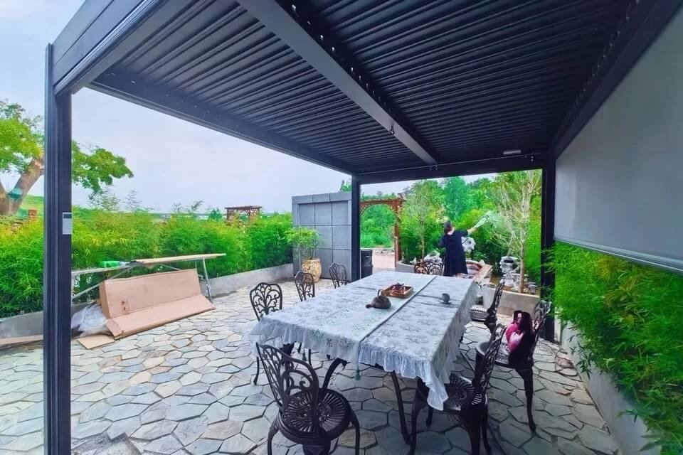 bioclimatic pergola featuring drop down privacy screens and outdoor dining setup for a hospitality project