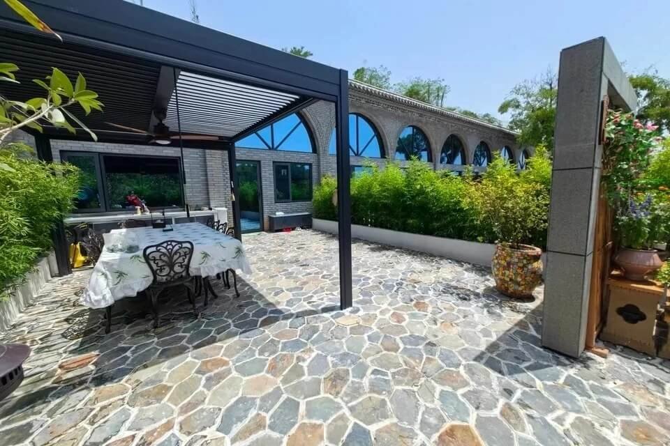 custom freestanding louvered roof system perfectly blending with traditional arched hotel architecture in morocco