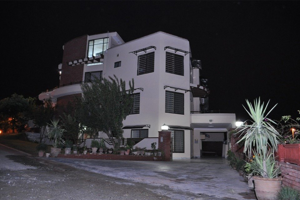 Multiple spliced aluminum arched canopies seamlessly mounted over extra-wide windows on a modern villa facade, providing reliable all-weather coverage.
