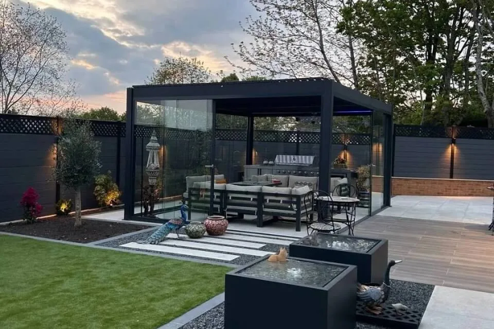 interior view of a custom black bioclimatic pergola with sliding glass doors and cozy patio furniture in los angeles