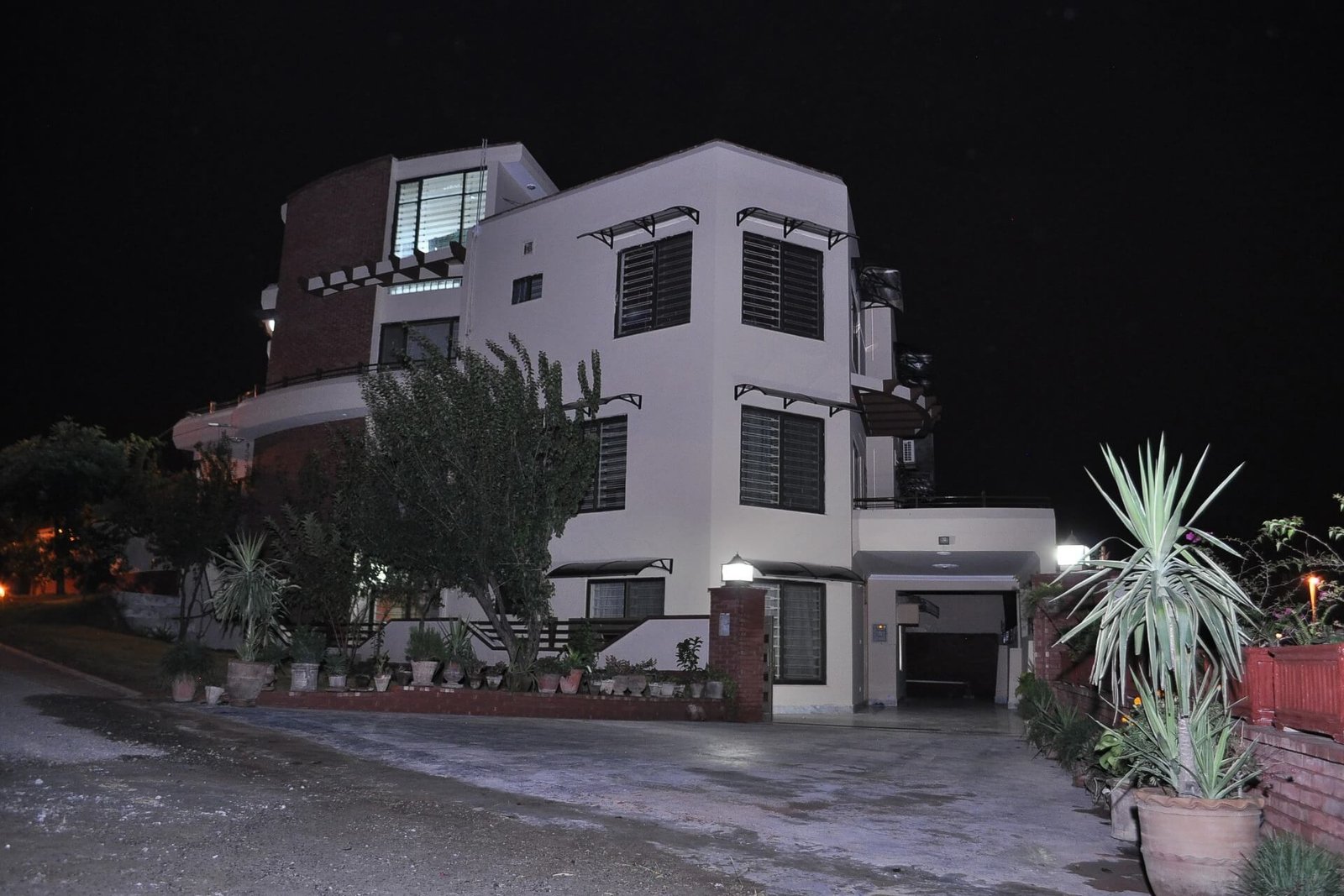A stunning night view of a luxury residential villa in Jordan, featuring custom modular arched window canopies installed across multiple floors for elegant exterior protection.