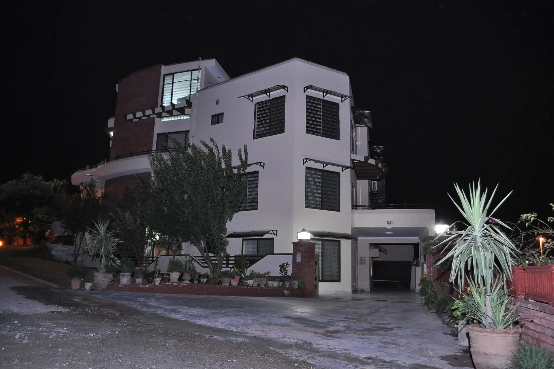 A stunning night view of a luxury residential villa in Jordan, featuring custom modular arched window canopies installed across multiple floors for elegant exterior protection.